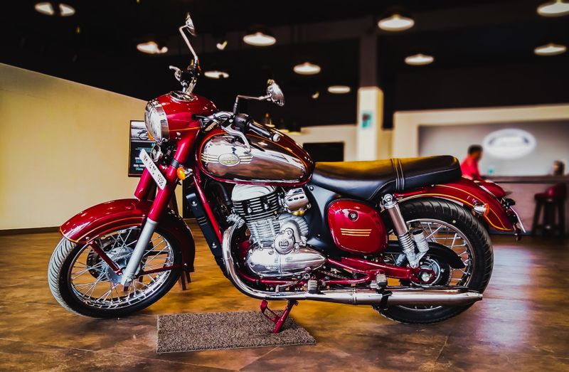 Moto classique rouge exposée dans un showroom sous un éclairage tamisé