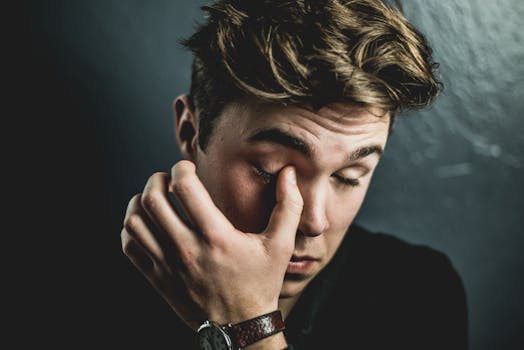 一位年轻人揉着眼睛的深思特写肖像，传达了情感与内省