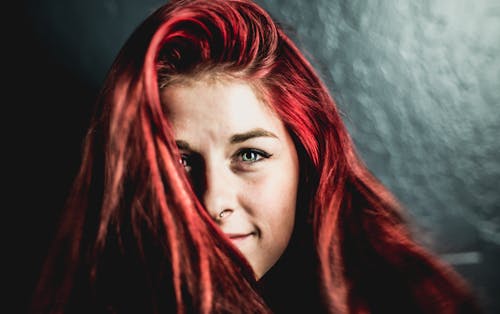 紅頭髮的微笑婦女的特寫照片