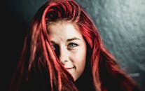 一位红发醒目、眼眸动人的女人微笑着的特写肖像