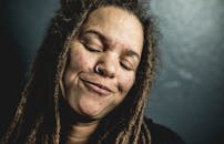 一位留着辫子的女人闭目微笑的特写肖像，神情平静