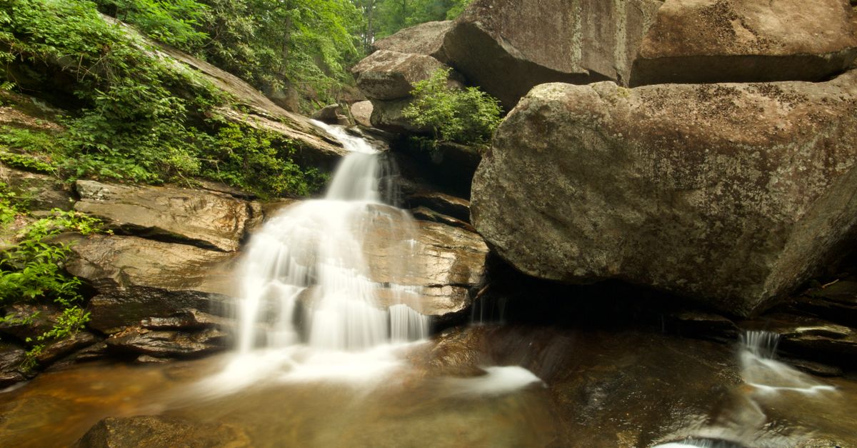 Tranquil waterfall cascading over rocks in a verdant North Carolina forest.