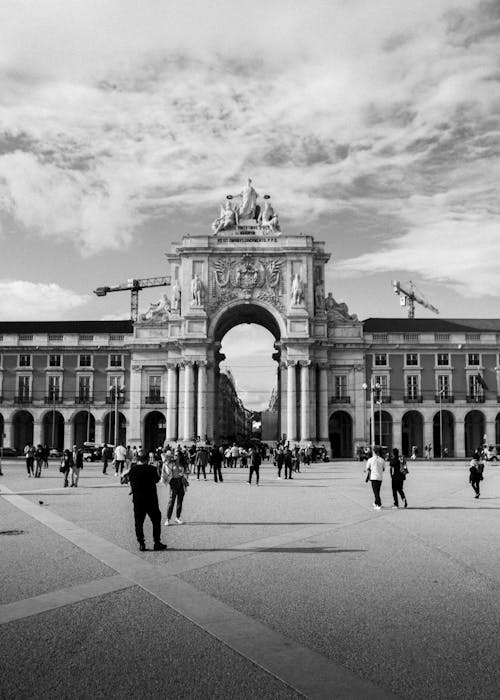 Black and white photo of people walking around a square