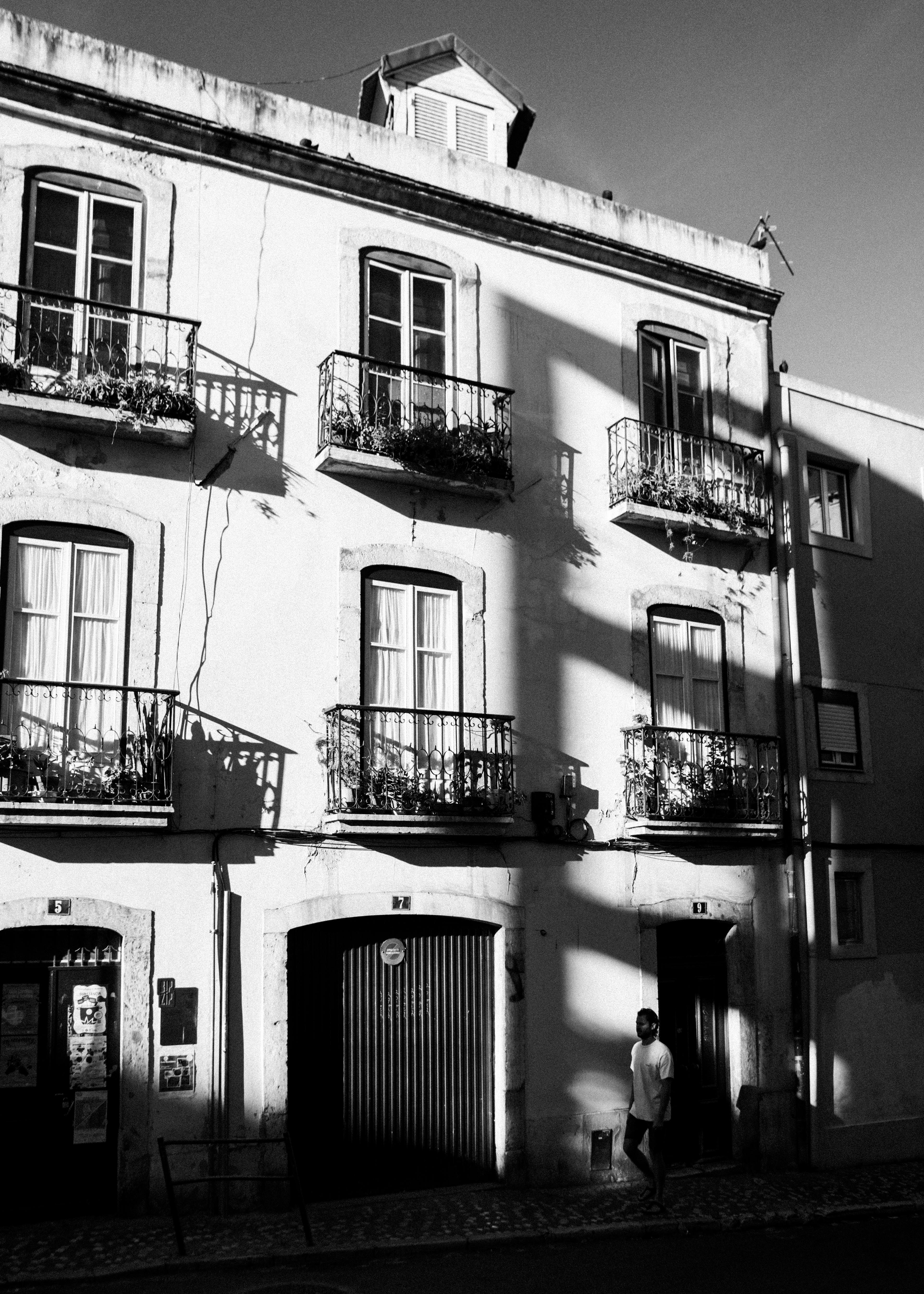 Elegant European building facade in black and white with striking shadows.