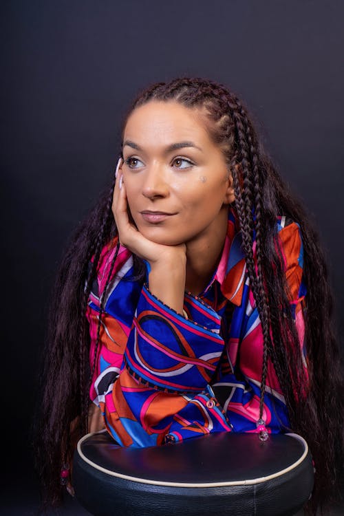 A woman with long hair sitting on a stool