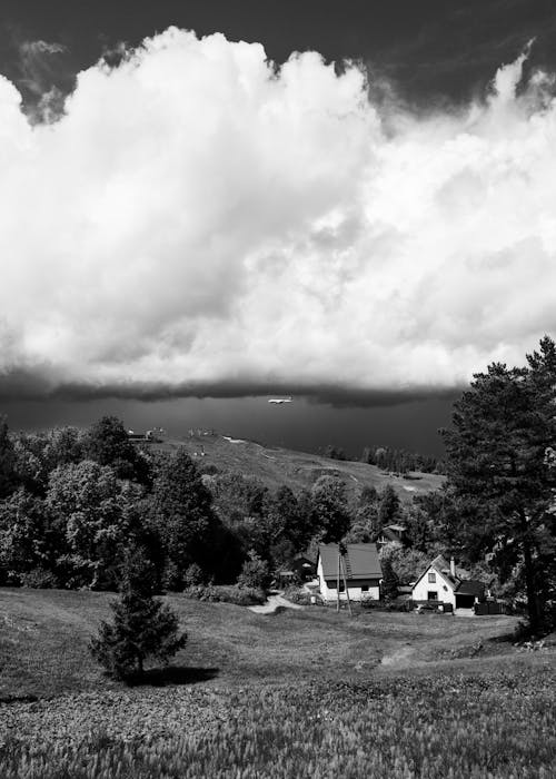 Black and white photograph of a farm with a storm