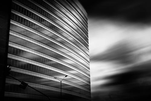 Black and white photo of a building with clouds