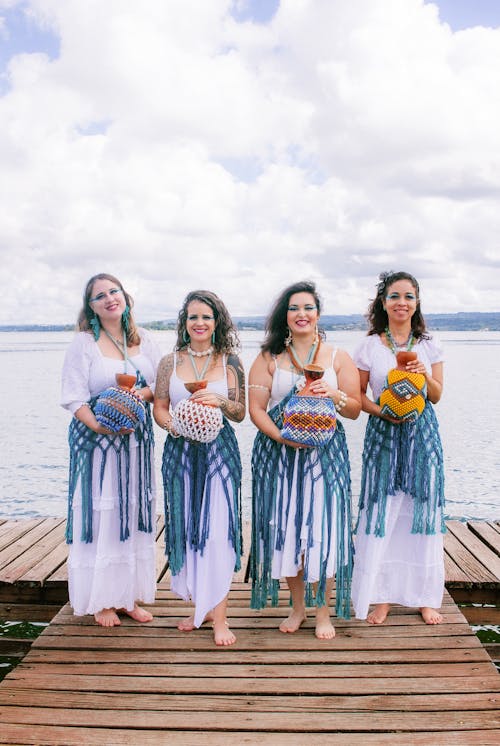 Free Four women in traditional dress pose on a dock Stock Photo