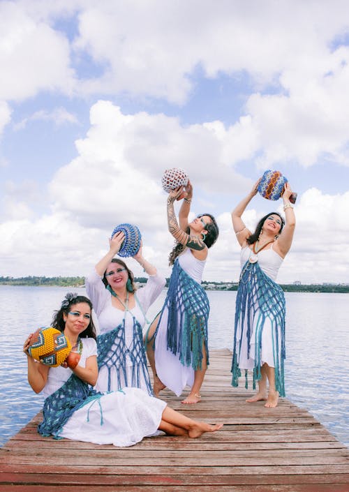 Free Three women in traditional dress pose on a dock Stock Photo