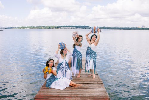 Free Four women in traditional dress pose on a dock Stock Photo