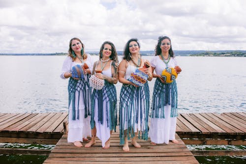Free Three women in traditional dress pose for a photo on a dock Stock Photo