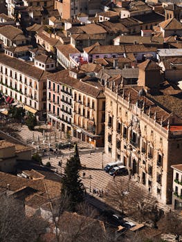 An aerial view showcasing Granada's historic square with traditional architecture under bright sunlight.