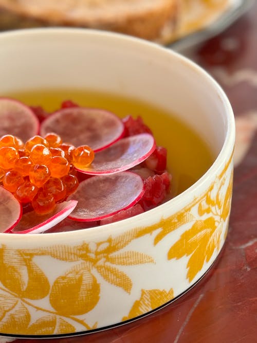 A bowl of food with red caviar and radishes