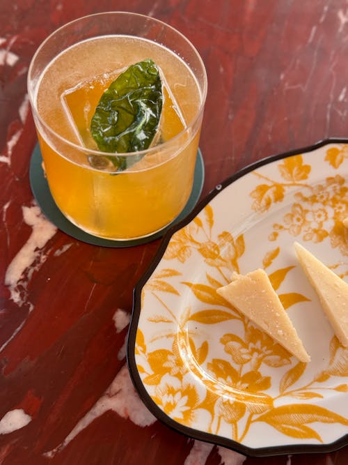 A glass of orange juice and a slice of cheese