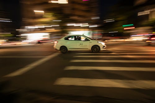 White Taxi on Street in City at Night