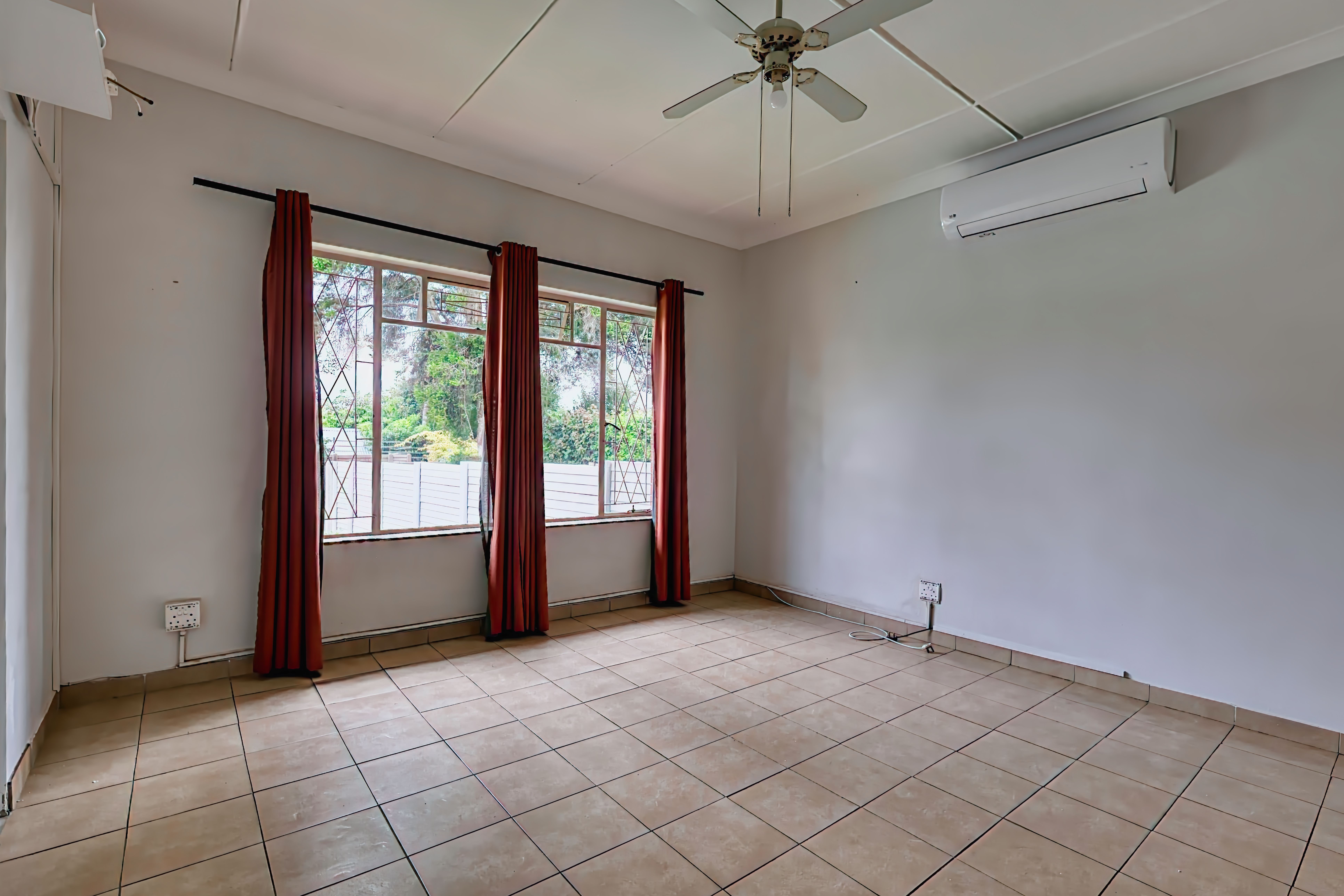 Sunlit room interior with large windows and drapes, capturing a modern minimalist design in Pretoria, South Africa.