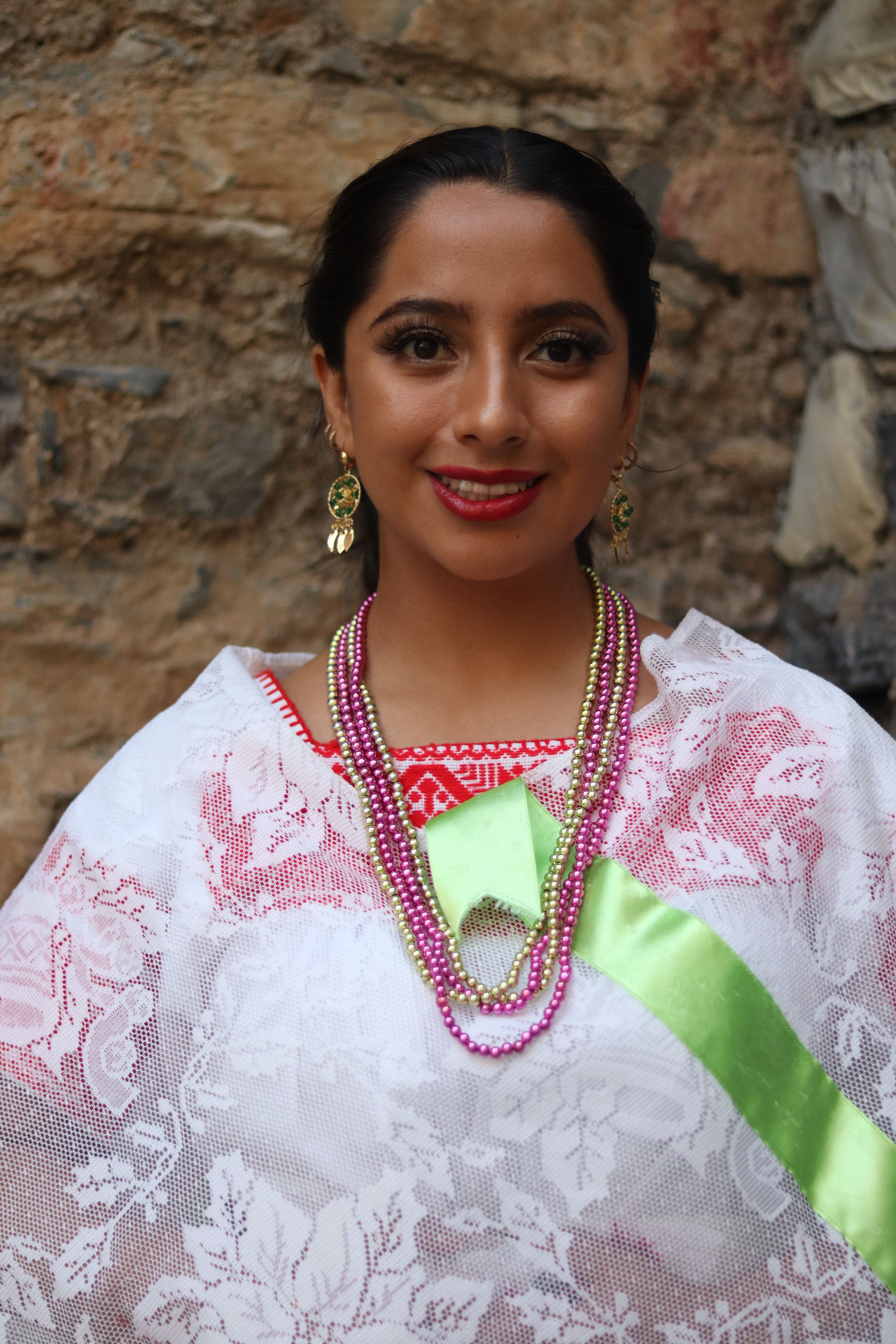 Portrait of a woman in traditional folklore attire with lace detailing and vibrant jewelry.