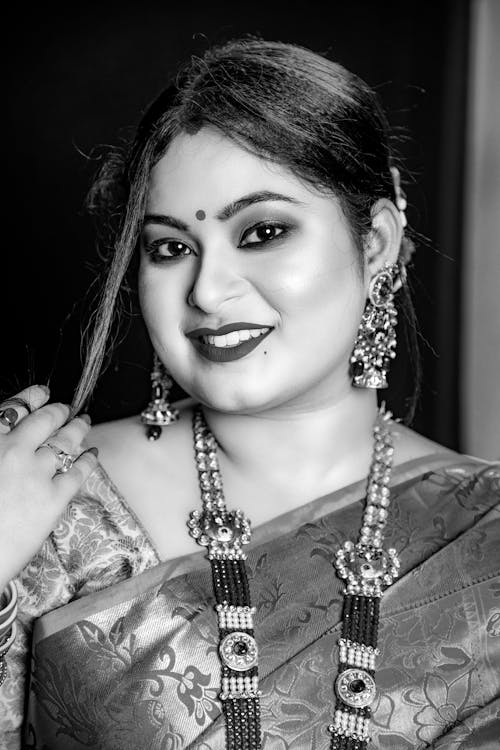 A woman in traditional attire posing for a black and white photo