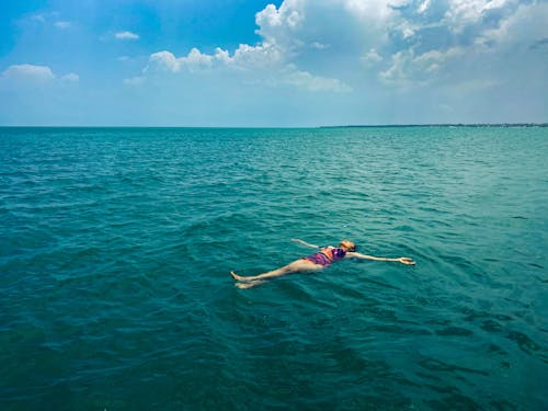 Free A woman floating in the ocean with her head above the water Stock Photo