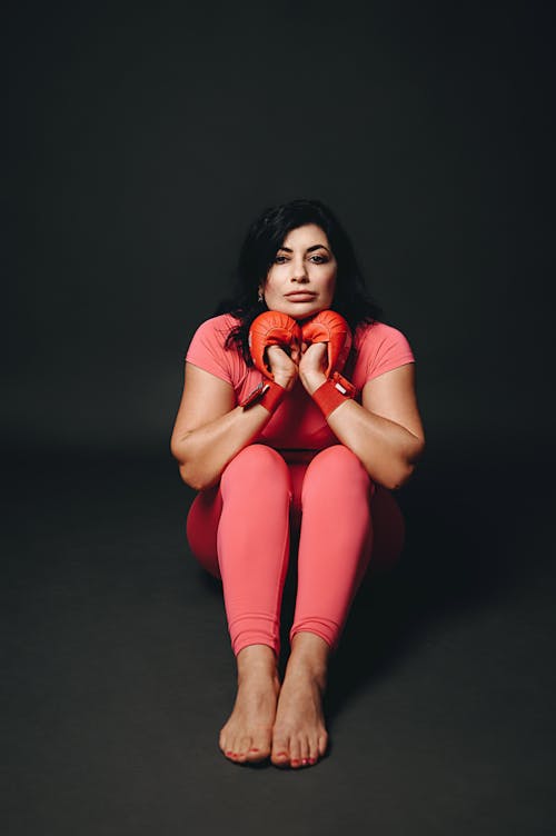 Free A woman in pink pants and gloves sitting on the floor Stock Photo