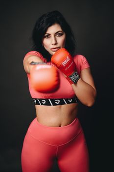 Determined female boxer in pink gear showcasing strength and focus.