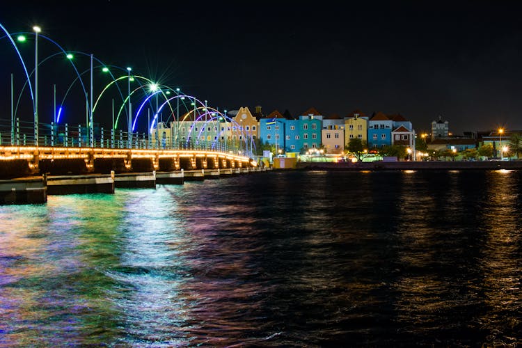 Assorted-color Buildings Near Body Of Water At Night