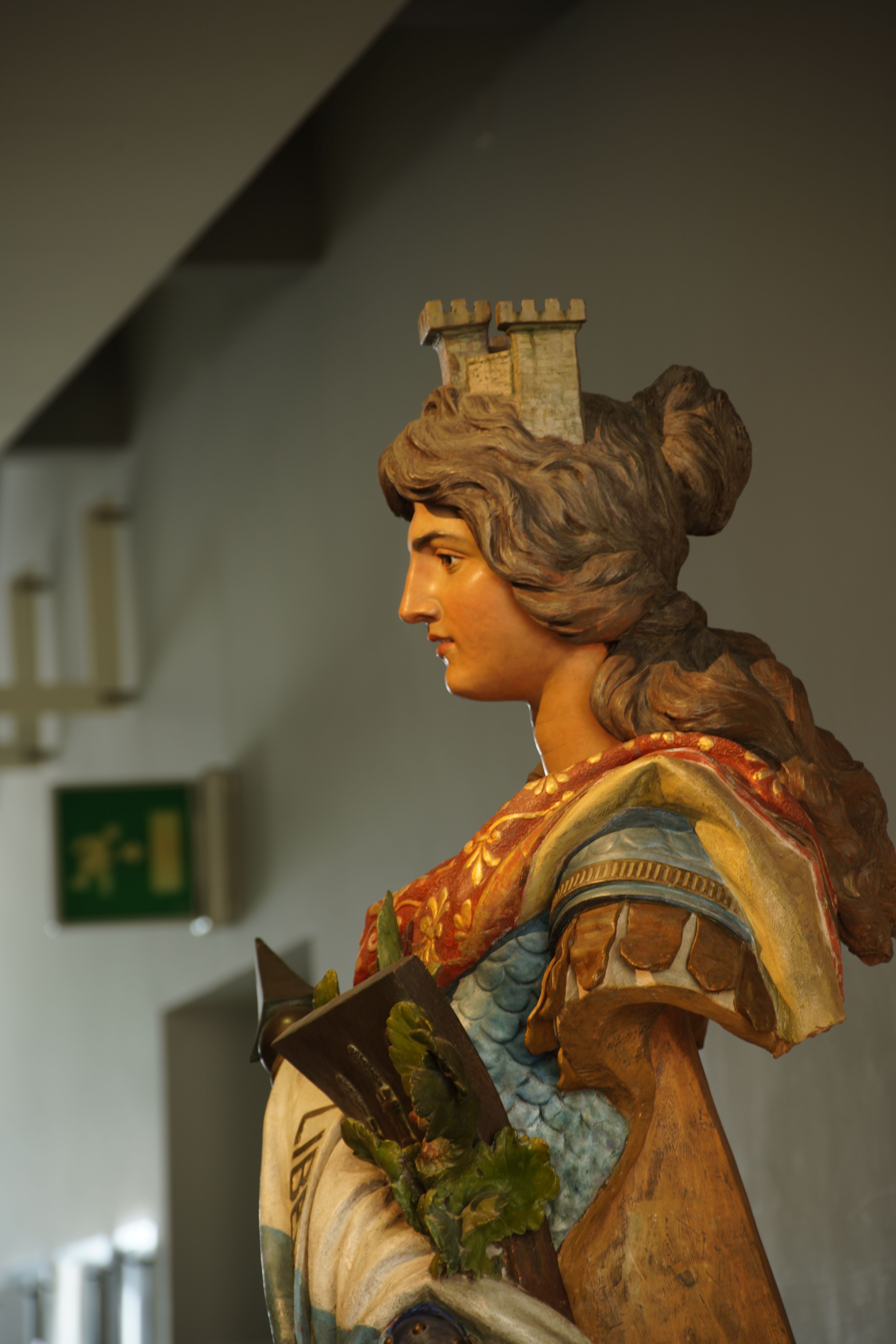 Detailed statue of a woman with a fortress crown at an art exhibition in San Marino.
