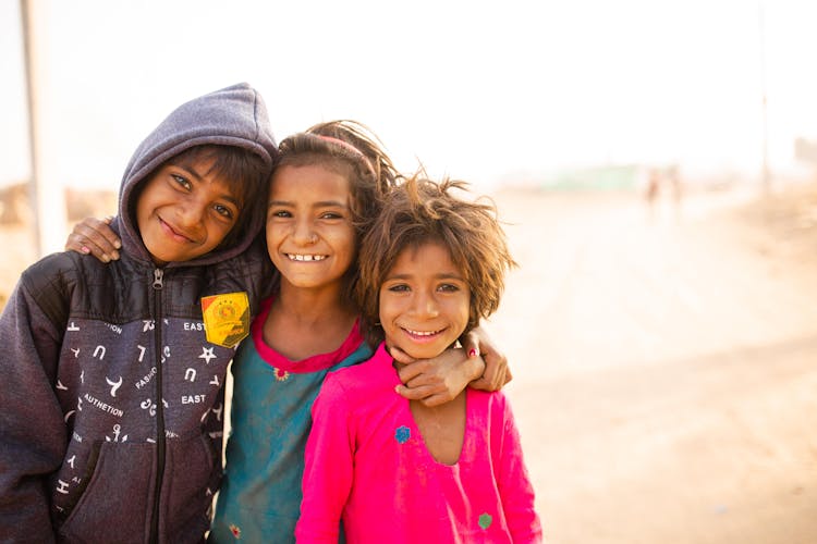 A Group Of Happy Children Standing In A Desert 