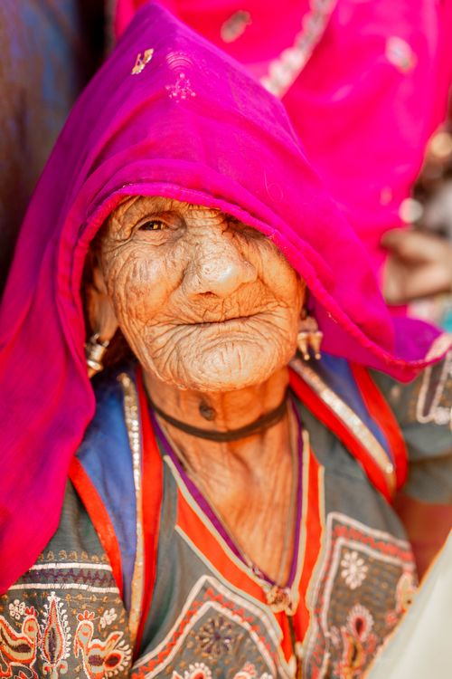 Free Portrait of an elderly Indian woman in bright traditional clothing and pink headscarf, Pushkar, India. Stock Photo