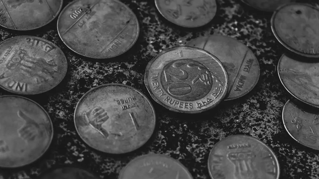 Black and white close-up of scattered Indian rupee coins