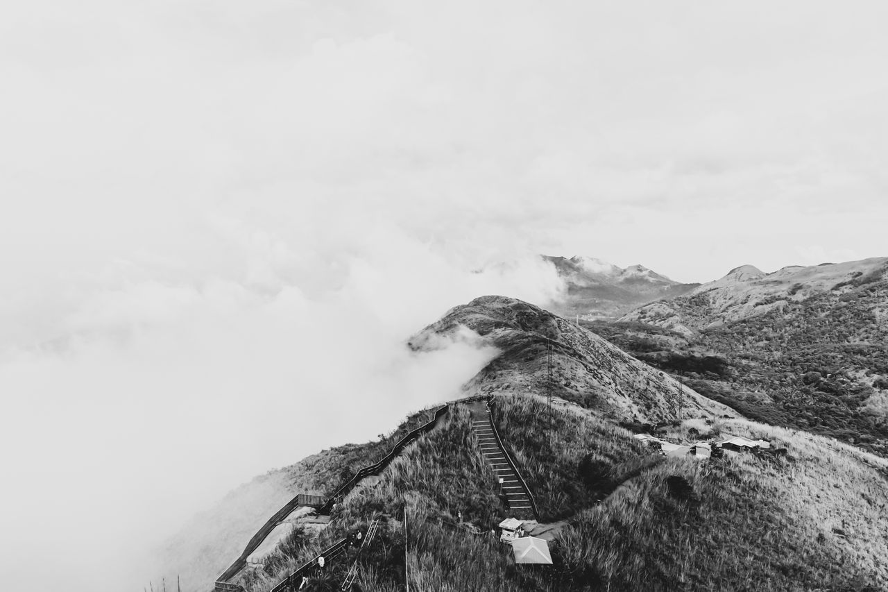 a stunning aerial shot of mist covered hills and trails in kottayam ke