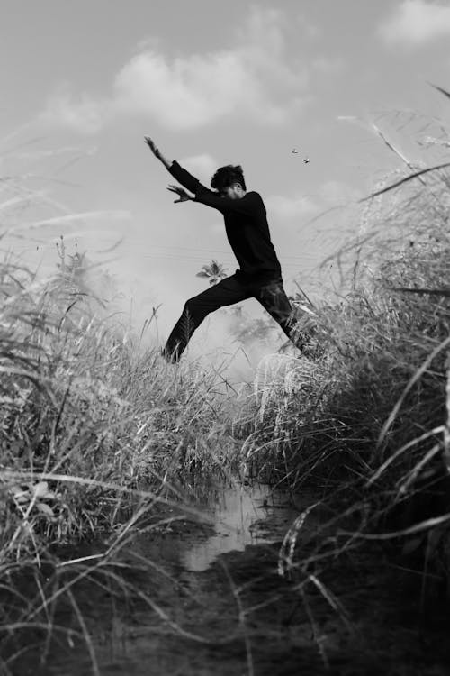 black and white frame of men jumping 