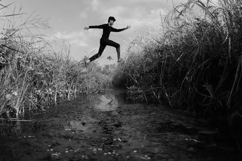 black and white frame of men jumping 