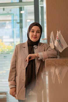 Portrait of a woman in business attire standing confidently at an office setting.