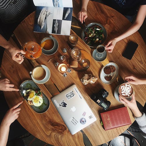 Free People Holding Cups and Mugs by Table Stock Photo