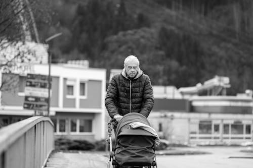 Foto profissional grátis de andando, avô, carrinho de bebê