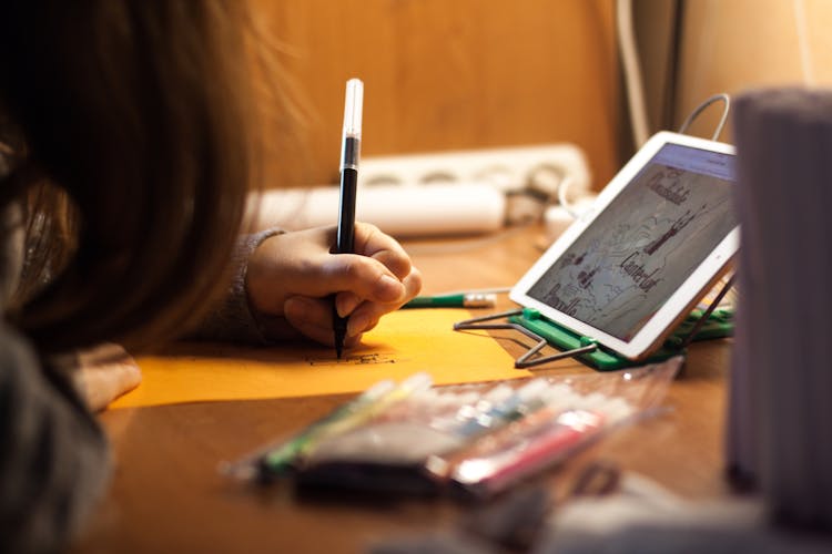 Woman Writing On Orange Paper