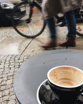 在柏林，骑自行车的人经过桌子上的咖啡杯