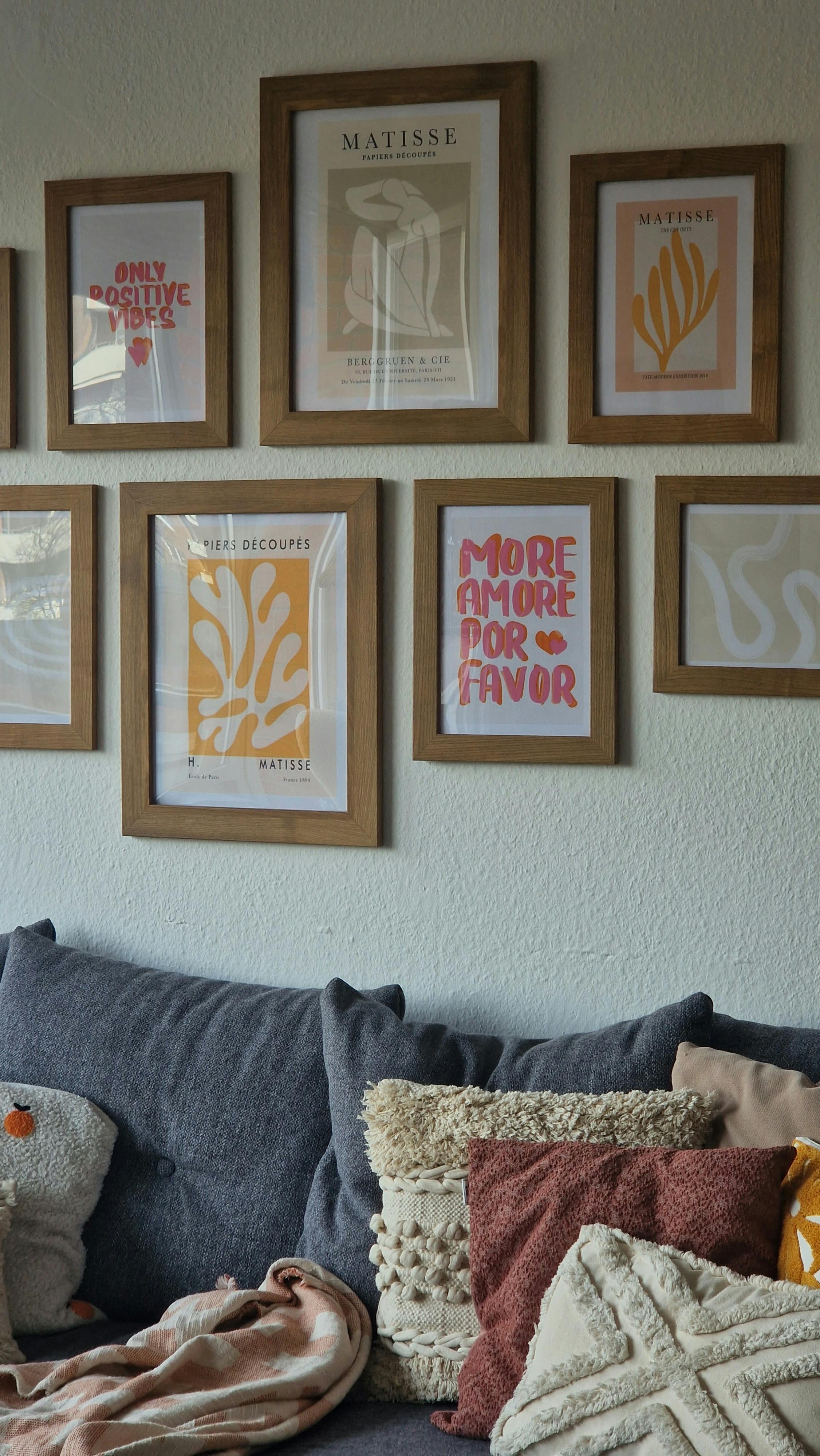 Stylish living room featuring art prints, cozy pillows, and a comfortable grey sofa.
