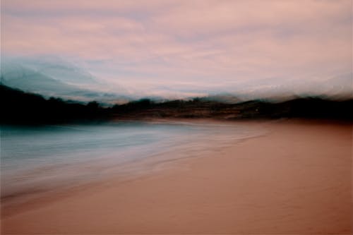 A blurry photo of a beach with clouds