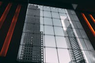 透过大型玻璃中庭的几何设计，欣赏现代摩天大楼