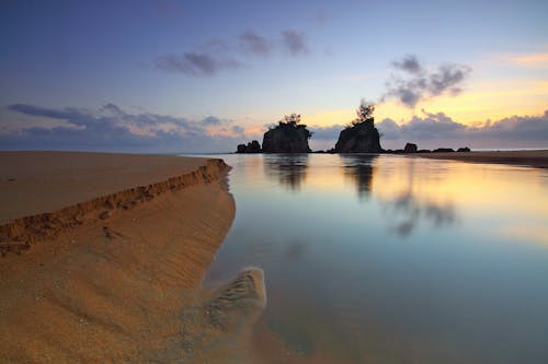 Foto Siluet Pulau Dengan Refleksi Badan Air