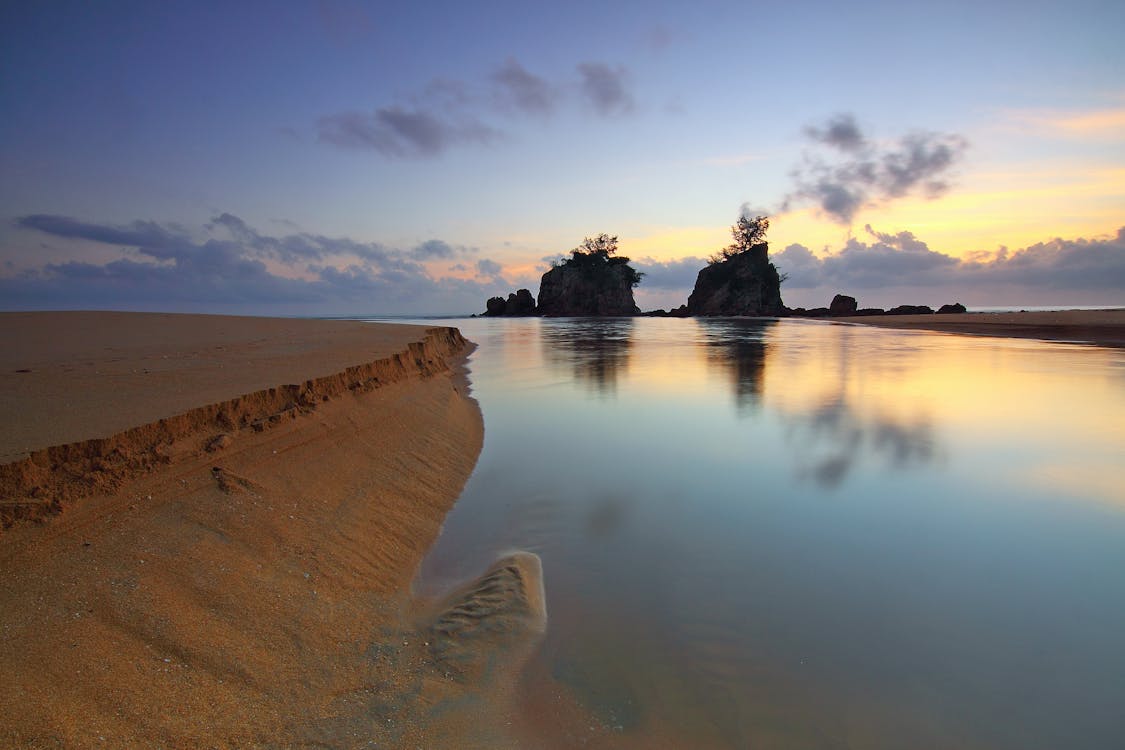 무료 물 몸에 반사 된 섬의 실루엣 사진 스톡 사진