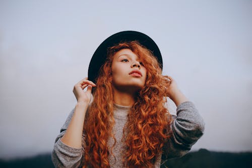 Mujer Pelirroja Con Sombrero Redondo Negro