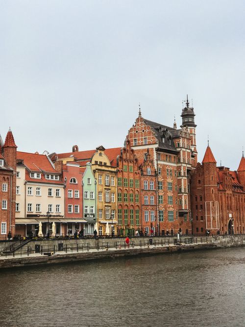 Free Picturesque view of colorful historic buildings along the river in Gdańsk, Poland. Stock Photo
