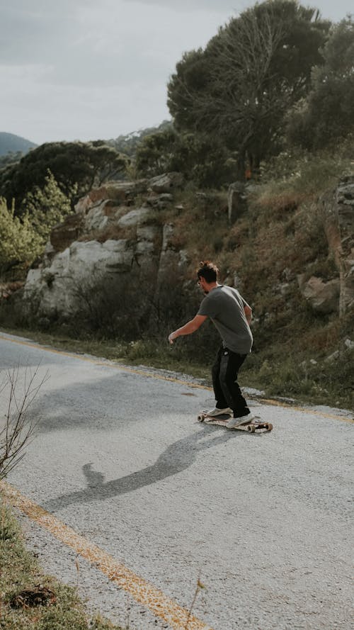 A man riding a skateboard down a road