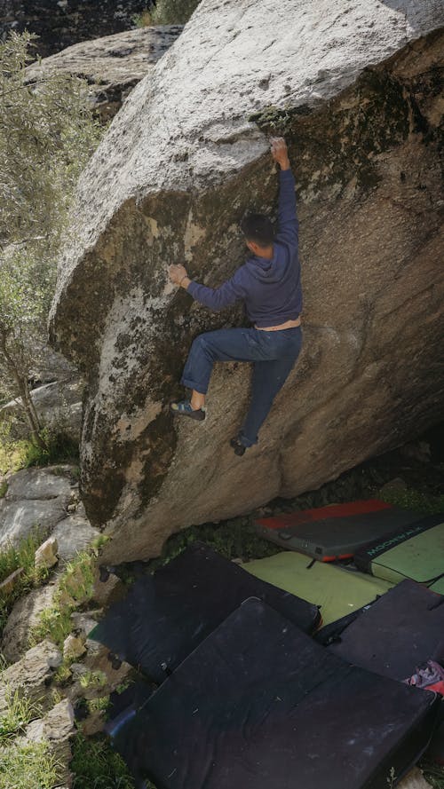 A man climbing up a rock with a backpack