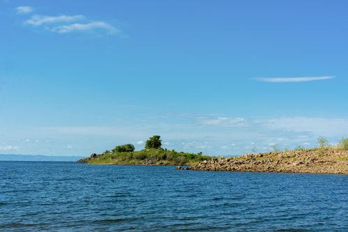 Free A tranquil island scene with clear waters and blue skies, perfect for nature and travel imagery. Stock Photo
