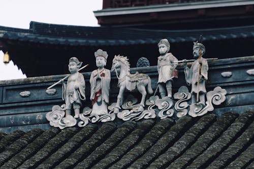 A group of statues on top of a roof