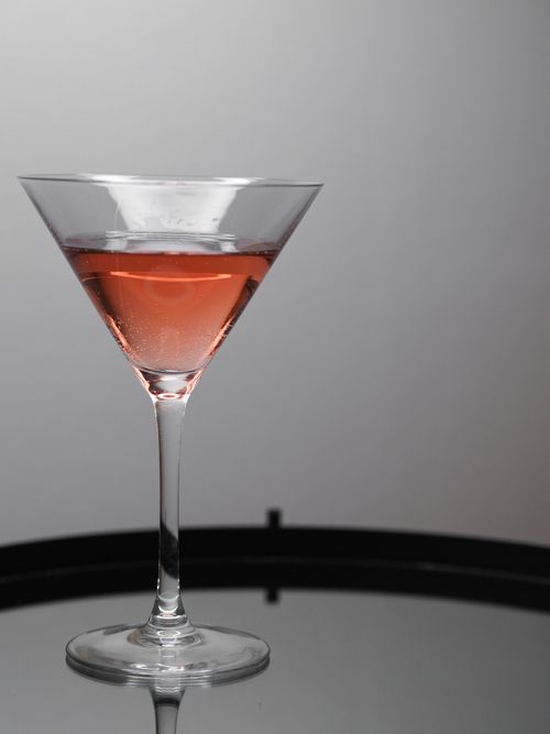 Free A classic martini glass with a pink cocktail on a reflective surface, studio setting. Stock Photo